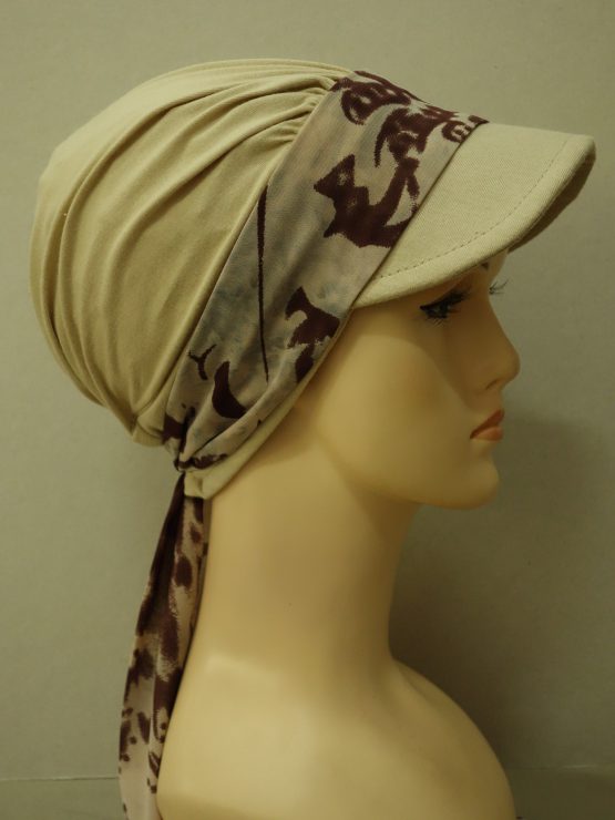 Modna czapka z daszkiem w kolorze beżowym z dokładaną, wzorzystą dekoracją w odcieniach brązu