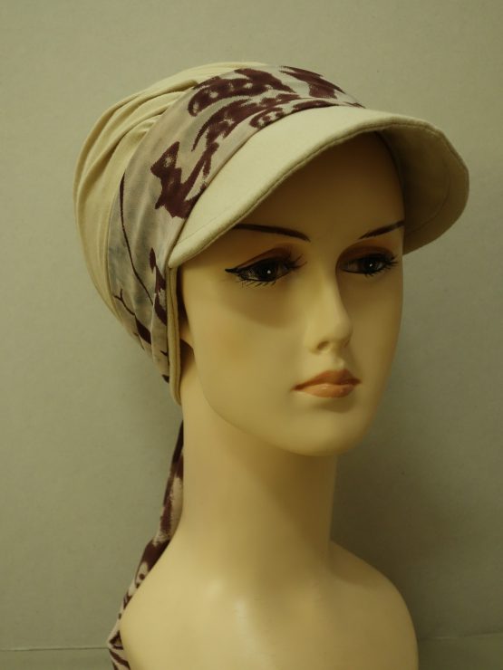 Modna czapka z daszkiem w kolorze beżowym z dokładaną, wzorzystą dekoracją w odcieniach brązu